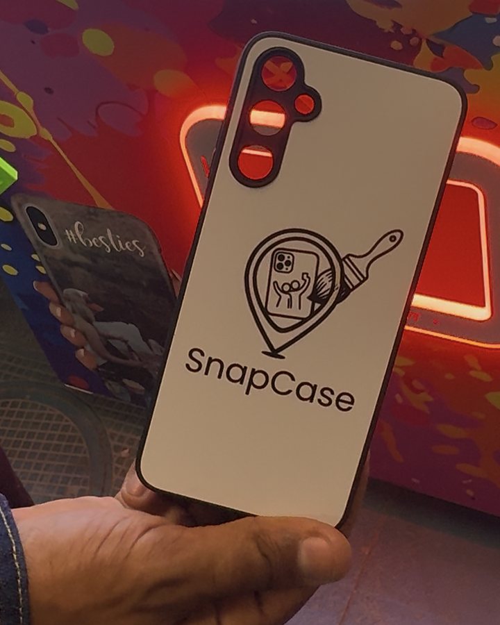 Une coque de téléphone tout juste imprimée, tenue en main devant le distributeur